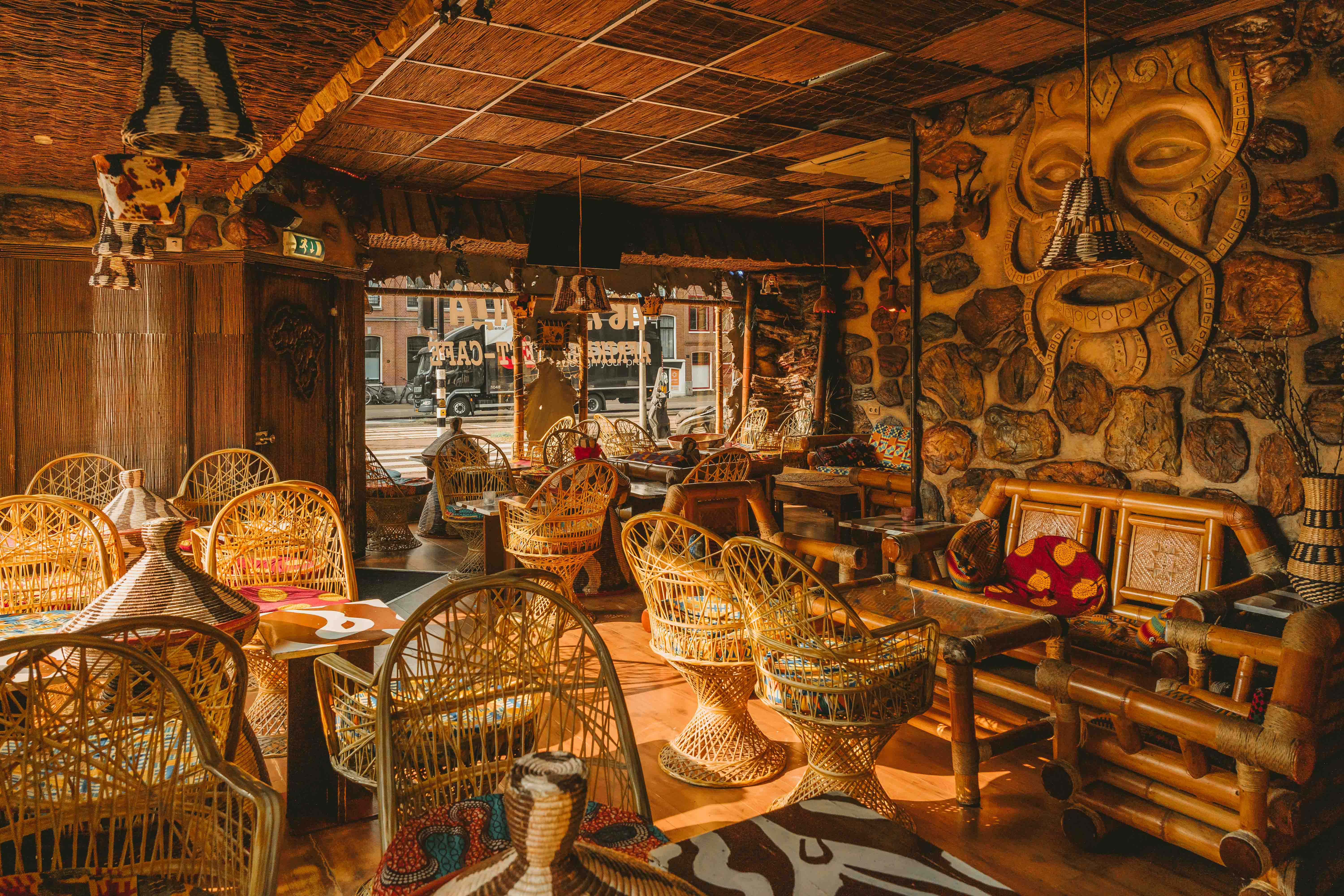 Warm sunlight in Abyssinia's dining room with woven chairs and traditional decor